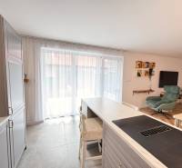 Kitchen and living room in a family house with modern furniture and large windows.