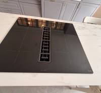 Induction cooktop in the kitchen with a marble countertop in a family house.