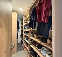 A wardrobe in a family house with shelves full of clothes and shoes.
