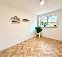 White room in a family house with wooden decor and plants on the shelves.