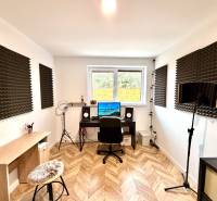Recording studio in a family house with a wood-patterned floor and acoustic panels.