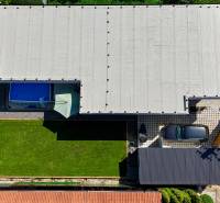 Aerial view of a family house in Šelpice with a garden and a swimming pool.