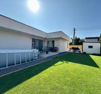 A family house in Šelpice with a garden, an above-ground pool, and a lawn.