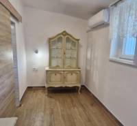 A room with a wooden decor floor in a 2-room apartment, decorative furniture, and air conditioning.