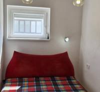 Small bedroom of a two-room apartment with a bed and hanging lights.
