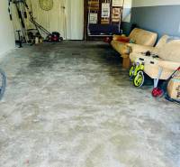 A garage in a 3-room apartment with tools and a couch, suitable for storage.