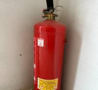 Fire extinguisher in the corner of the Garage space on the concrete floor.