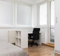 Interior of a 2-room apartment with a writing desk, chair, and floor with wood decor.