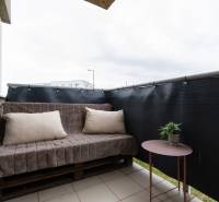 Balcony of a 2-room apartment with a sofa and a table on Hlavná Street in Biely Kostol.