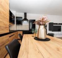 Interior of a 2-room apartment with a kitchen featuring wooden decor and flowers on the table.