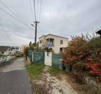 A family house on Gaštanová Street in Vinica surrounded by greenery near an asphalt road.