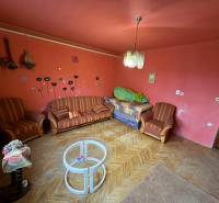 Living room in a family house with red walls and counter furniture.
