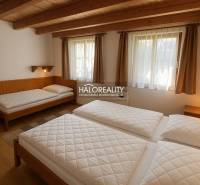 A bathroom in a cabin with tiled walls, a shower, a sink, and a mirror.