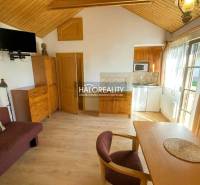 The interior of a cabin with a wooden decor floor, a dining table, and a television.