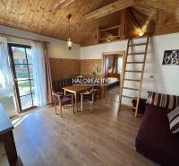 A bedroom with three beds, a wooden ceiling, a floor with a wood decor, and a cabinet.