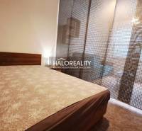 Furnishing a bedroom in a studio apartment with carpeted flooring and dark curtains.