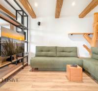 Living room in a 3-room apartment with a green sofa and a wooden decor floor.