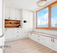 The kitchen in a 3-room apartment with white cabinets and a floor with a wood design.