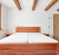 Bedroom in a 3-room apartment with light wooden furniture and ceiling beams.