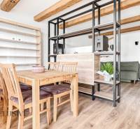 Dining area with a table and chairs, shelves, and a floor with a wooden decor in a 3-room apartment.