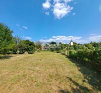 A spacious plot of land near a family house in Zvolen with a view of the tower, surrounded by greenery.