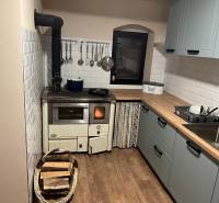 Rustic kitchen in a cabin with wooden decor and a wood-burning stove.