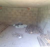 A wood storage in a family house in Hokovce with brick walls and a concrete floor.