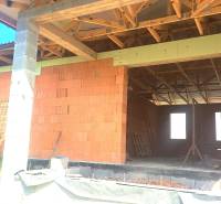 An unfinished family house in Hokovce with a brick construction and wooden beams on the roof.