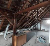 Attic of a family house on Štúrova, with wooden beams and clutter.