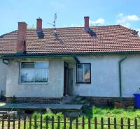 Family house on Štúrova Street, fence, blue container, brick roof.