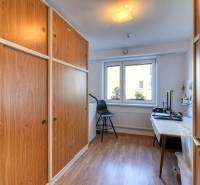 Interior of a family house with a wood-decor floor and large built-in wardrobes.