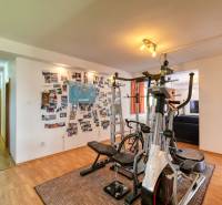 A gym in a family house with a wooden decor floor and postcards on the wall.