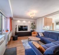 Living room with a dark blue sofa and a wooden decor floor in a family house.