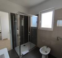 A bathroom with a modern shower and bidet in a 3-room apartment.