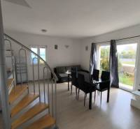 Living room with dining area, spiral staircase, and a view outside in a 3-room apartment.