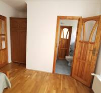 Interior of a family house with a wooden decor floor and a view into the bathroom.