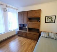 Interior of a family house with a bed, wardrobe, and floor with wooden decor.
