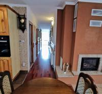 Interior of a family house with a dining room, fireplace, and wooden decor flooring.