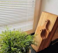 A room in a family house with a flower and wooden boards on a black kitchen counter.
