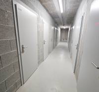 A corridor with white doors in the basement premises of the building at Bottova Street 6, Bratislava.
