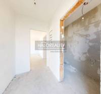 A hallway in a family house with unpainted walls and a room ready for renovation.