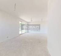 A spacious room with large windows in a family house, waiting to be finished.