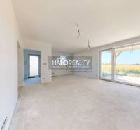 A spacious room with large windows and a view of the garden in a family house.