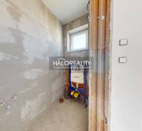 Bathroom space in a family house with rough walls and a window.
