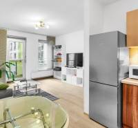 Living room with a kitchenette in a 2-room apartment with a wooden decor floor and furnishings.