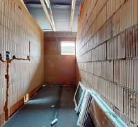 Construction of a family house with visible brick walls and ceiling beams.