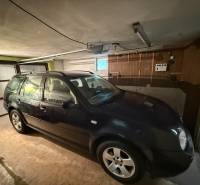 A car parked in a garage in a family house. Floor with wooden decor.