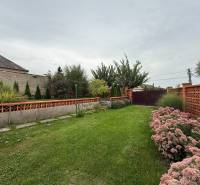 A garden in a family house on Jilemnického Street in Dvory nad Žitavou with flowers and a lawn.