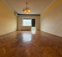 Living room in a family house with a wooden decor floor and a chandelier.