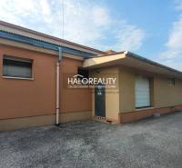 The exterior of commercial premises in Čakajovce with an orange facade and a paved parking lot.